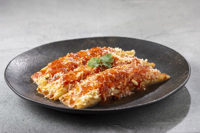 Pancakes stuffed with minced meat and topped with tomato sauce and grated cheese.