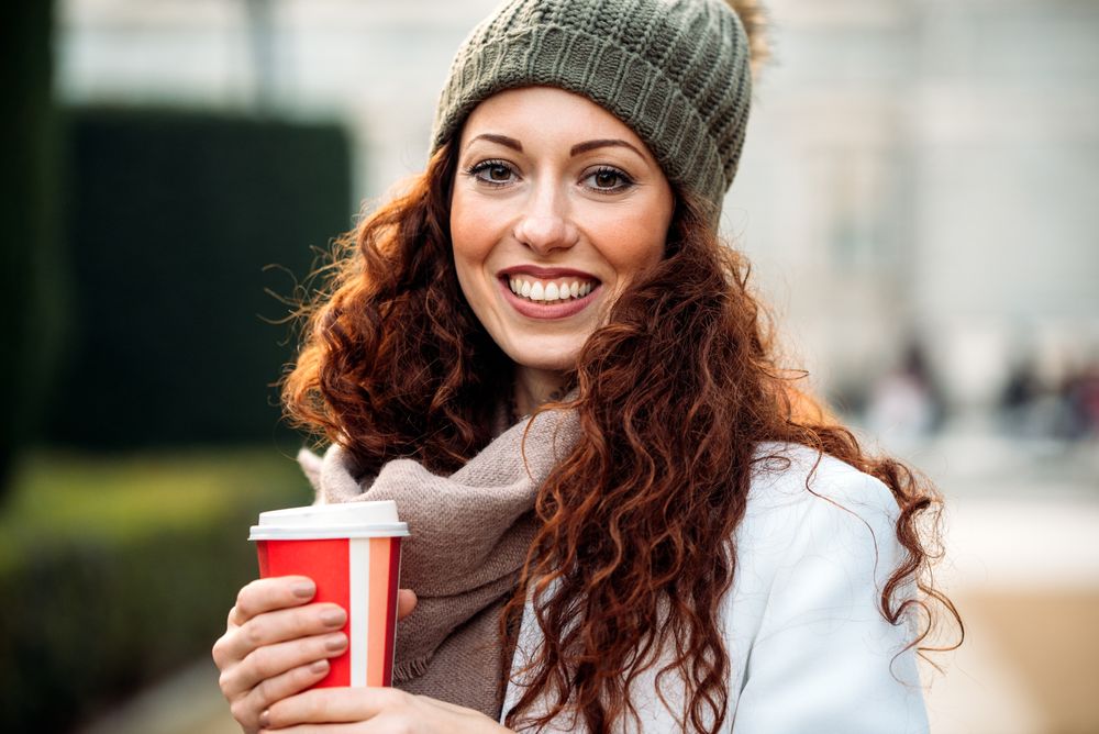Beautiful woman drinking coffee in the streets of Madrid on winter