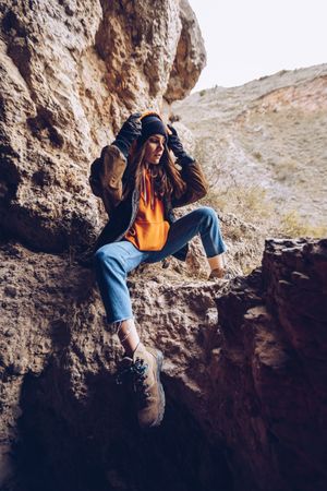 Neutral female hiker resting in rocky slope