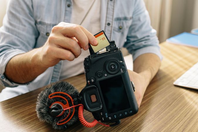 Man inserting memory card to a camera