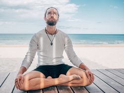 Man meditating on beach