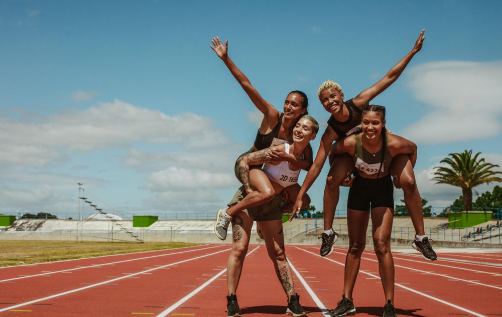 Group Of Women Athletes Running In Stadium During Athletics