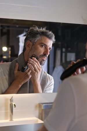 Mature male doing morning routine and shaving at home