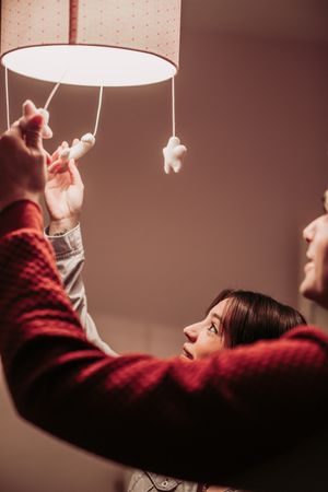 Expecting couple lighting chandelier in baby room