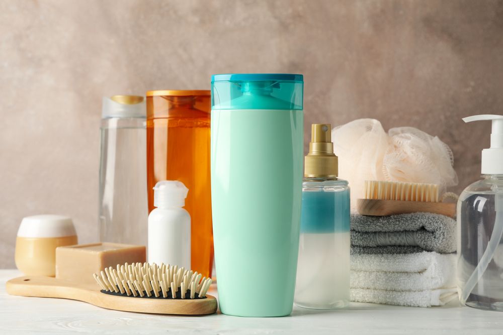Composition with hair care products on wooden table. Blank space for label