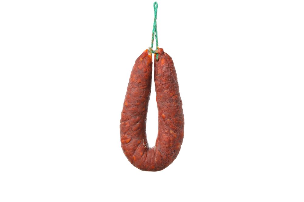 Cured chorizo hanging in blank room