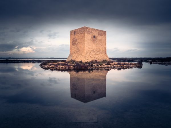 Wonderful watchtower in calm lake on cloudy day