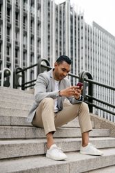 Man sitting on stairs using smartphone