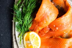 Top view of raw herring fish on plate served with dill and lemon