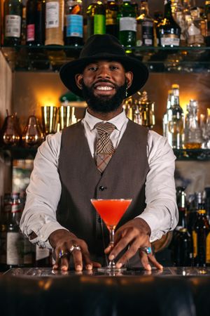 Stylish bartender offering a cocktail