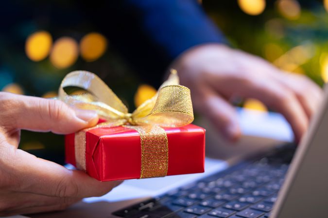 Businessman Holding Gift at Laptop