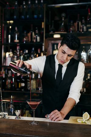Barman working mixing pouring drink in a glass
