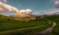 Picturesque landscape of green plain with house and mountains
