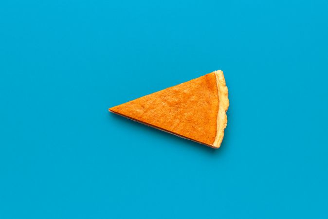 One pumpkin pie slice isolated on a blue background
