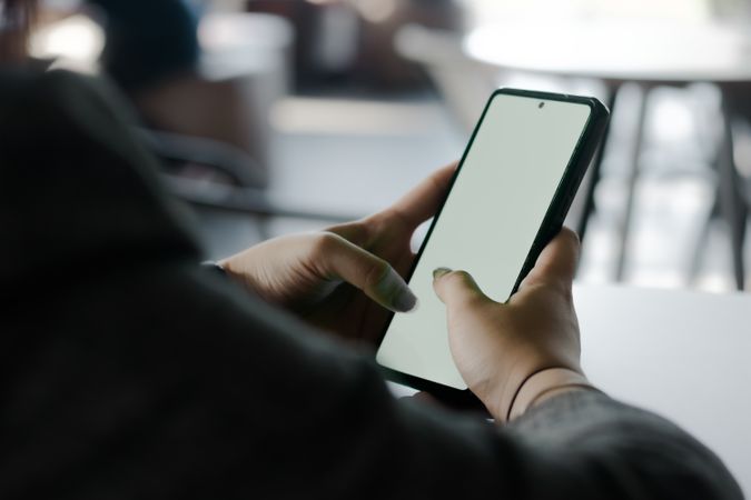 Digital interaction: Hands holding smartphone with blank display
