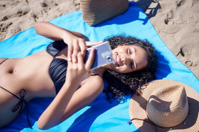 A Young Woman Happily Enjoying a Beautiful Sunny Day at the Beach While Taking a Selfie