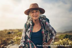 Close up of a smiling woman standing outdoors on a hiking trip 56v1x5