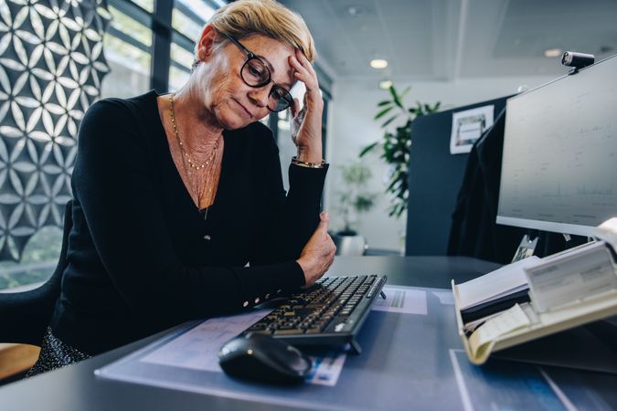 Unproductive tired woman sitting at her office desk