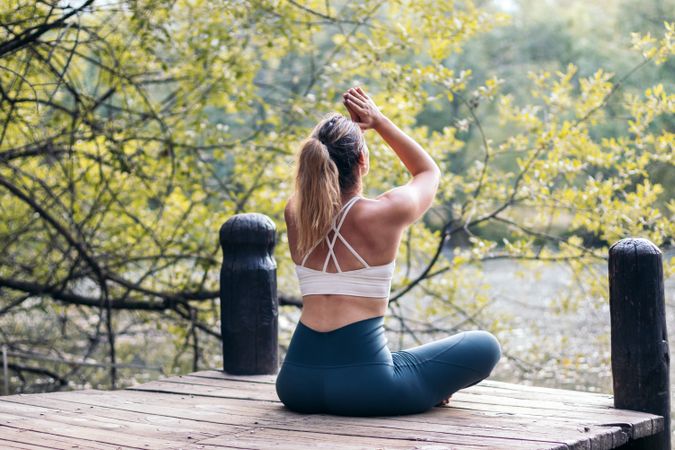 Woman meditating in nature near a lake