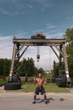Black guy with barbell in outdoor gym