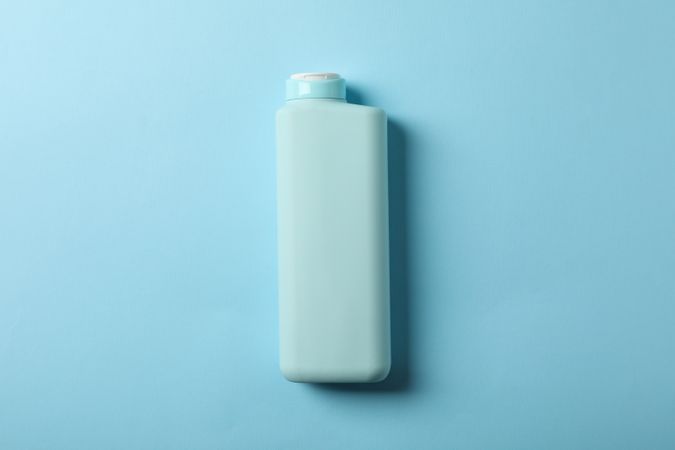 Blank shampoo bottle on blue background, space for text
