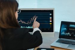Crop woman analyzing graph on binary option