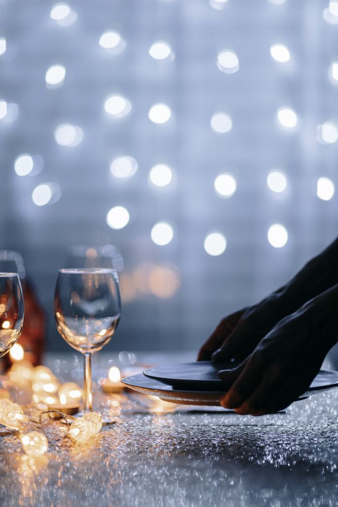 Hands setting plates on table