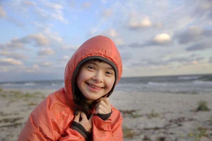 Happy female child wearing windbreaker on beach