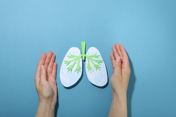 Blue background with hands surrounding lungs