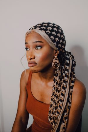 Black woman wearing headscarf and brown dress