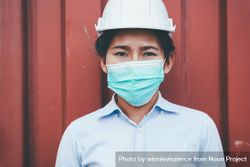 Portrait of logistic engineer woman wearing protective mask looking at camera 4ZvK14