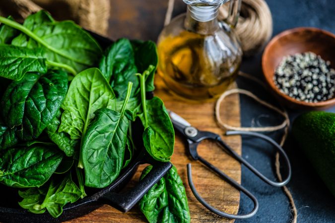 Fresh spinach leaves in kitchen with oil and seasoning