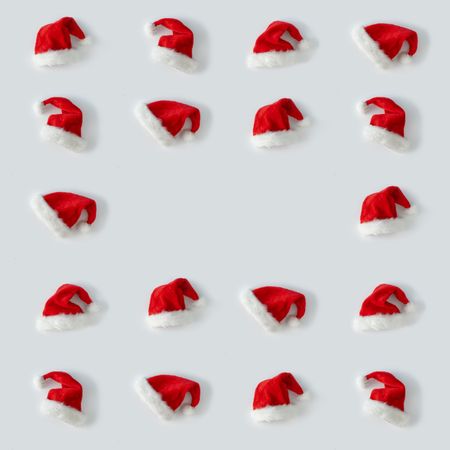 Santa hats arranged on light background