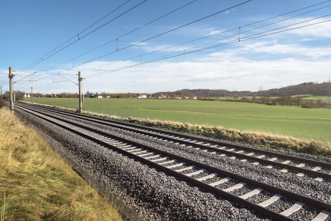 Railroad tracks through green meadow