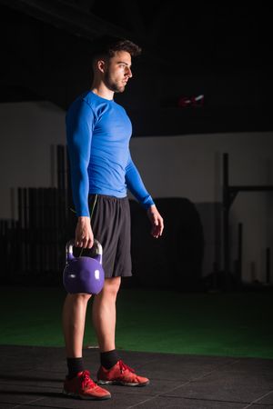 Man lifting kettlebell in gym