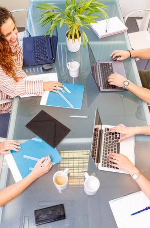 Faceless colleagues working at laptops in office