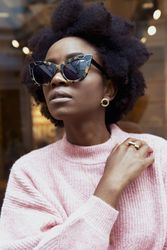 Black woman with sunglasses wearing pink sweater 0LXdg0