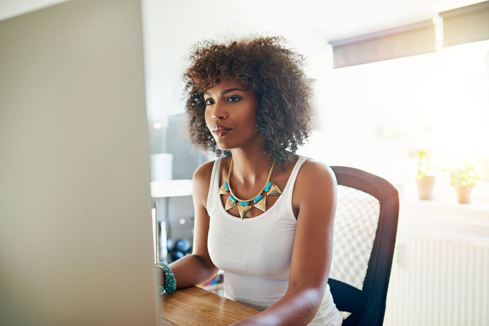 Female business owner working on computer in her bright home office
