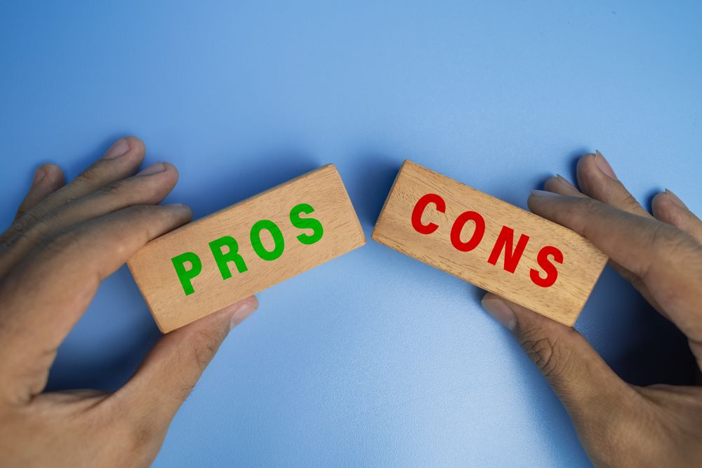 male hands holding pros and cons wooden blocks isolated on blue background