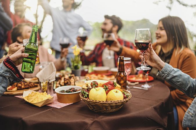 Happy people cheer at barbecue party in backyard