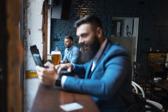 Two men sitting separate in a bar