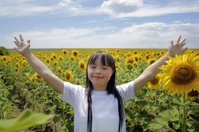 Happy girl standing in a field of sunflower