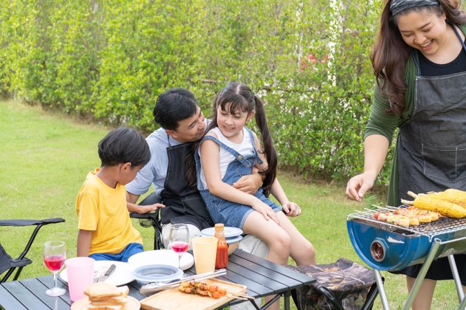 Mother making bbq for her husband, son and daughter
