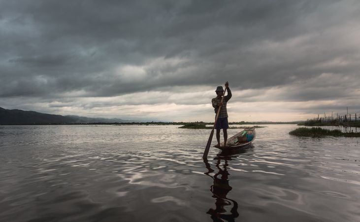 Shan, Myanmar - June, 25 2012: Anonymous fisherman standing on boat