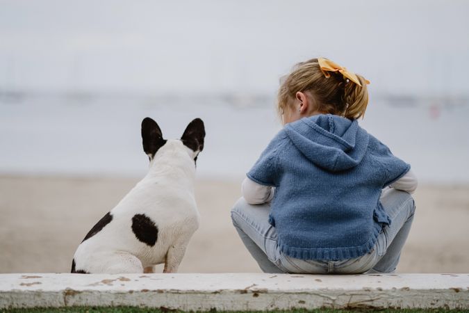 small girl near dog on beach
