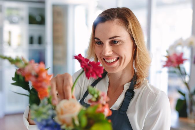 Smiling female florist preparing a bouquet