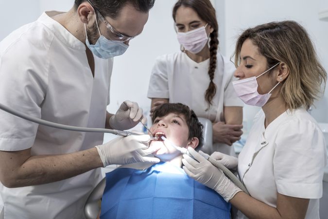 A portrait of dental team team working on young patient