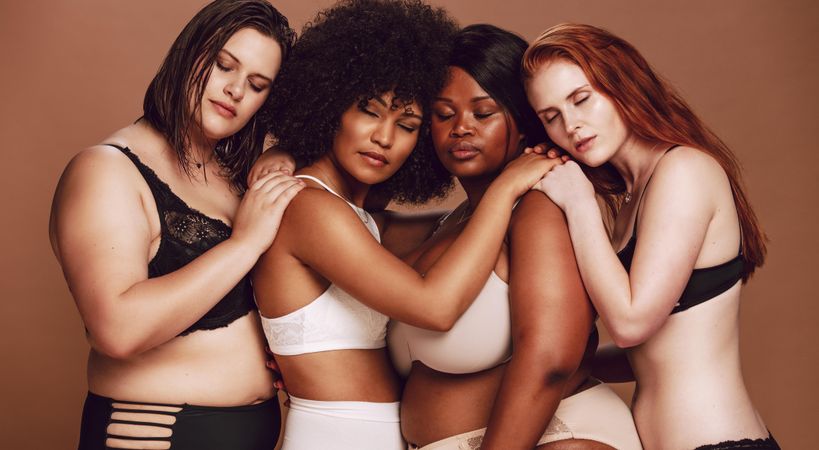 Female models of all body types leaning on each other with eyes closed