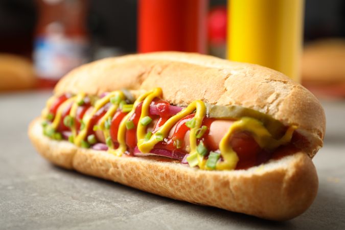 Tasty hot dog on gray table, close up