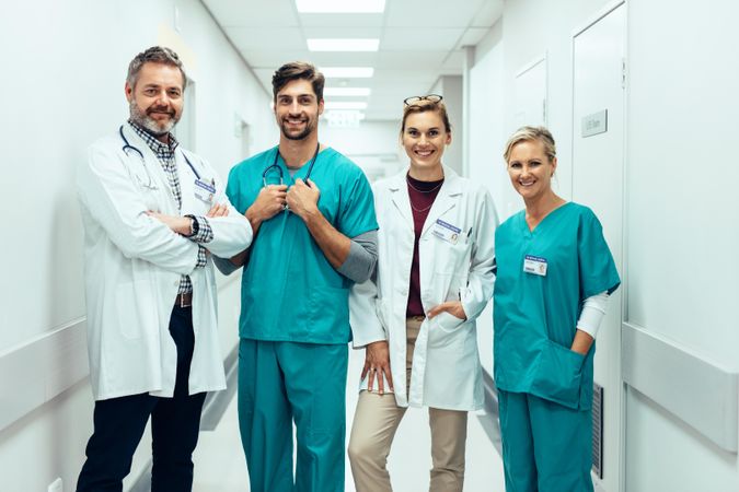 Group of paramedics smiling in hospital corridor